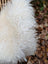 A plush white curly long wool icelandic sheepskin throw with soft voluminous texture perfect for cozy decor