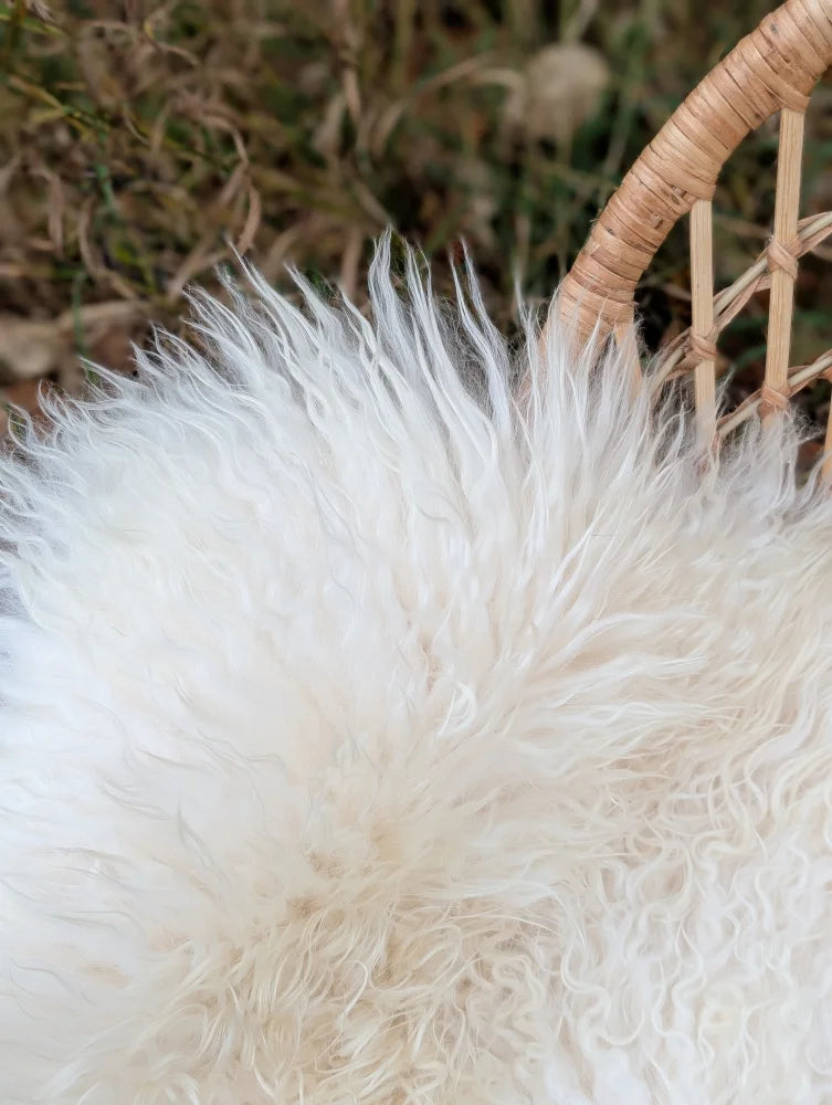 White fluffy wool icelandic sheepskin rug with long curly fibers in a woven basket ice5 48x31 inches