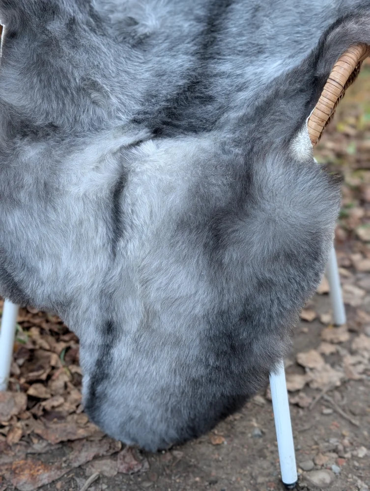 Gray faux fur rug with soft plush texture and natural shades made from massive long wool icelandic sheepskin