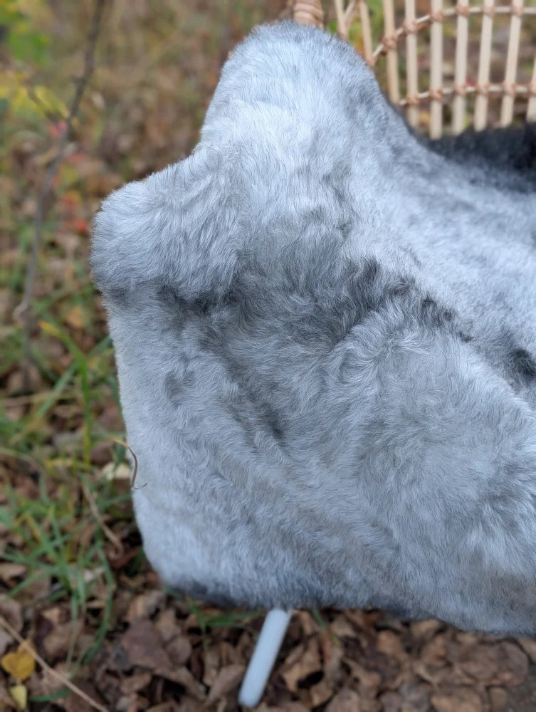 A soft plush gray faux fur hat with textured surface made from long wool icelandic sheepskin material