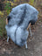 A plush gray and black icelandic sheepskin rug with long wool icelandic draped over a chair for cozy decor