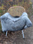 Gray faux fur throw draped on wicker chair featuring massive 53x32 long wool icelandic sheepskin natural grey design