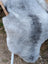 A soft fluffy natural grey icelandic sheepskin rug with long wool icelandic texture measuring 53 by 25 inches