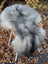 A plush long wool icelandic sheepskin rug in natural grey draped over a wicker leg chair for cozy decor
