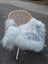 A light grey icelandic sheepskin throw draped over a wicker chair showcasing long wool icelandic sheepskins