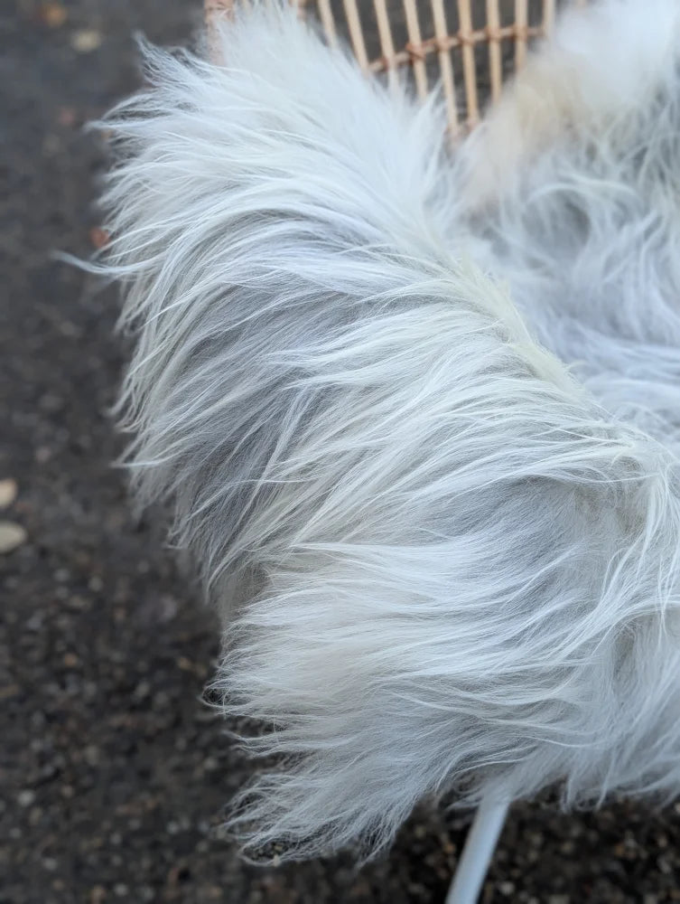 A fluffy white faux fur coat with long soft strands and plush texture inspired by grey icelandic sheepskin wool