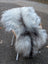 A plush 56 x 35 grey icelandic sheepskin rug with long wool draped over a chair for cozy decor