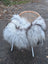 A long wool icelandic fluffy grey icelandic sheepskin throw draped over a woven wicker chair with metal legs