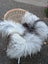 A fluffly grey icelandic sheepskin throw draped over a wicker chair showcasing long wool icelandic sheepskins