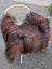 A plush long wool icelandic sheepskin throw in dark rusty colors draped over a wicker chair for cozy style