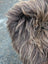 Fluffy shaggy tail of long wool icelandic sheepskin with dark rusty brown and lighter tan fur on the back side