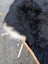 A brown woven leash attached to a black and white dog on an ice28 long wool natural black icelandic sheepskin