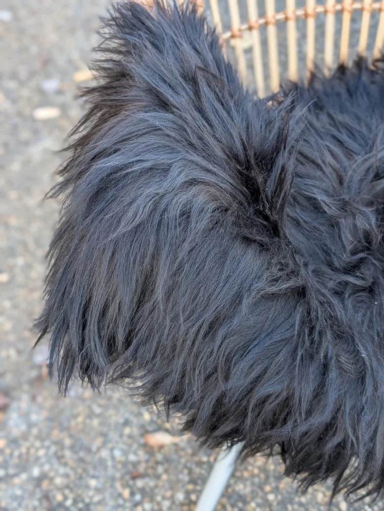 A plush black long wool icelandic sheepskin with dense shaggy texture perfect for cozy decor or wear