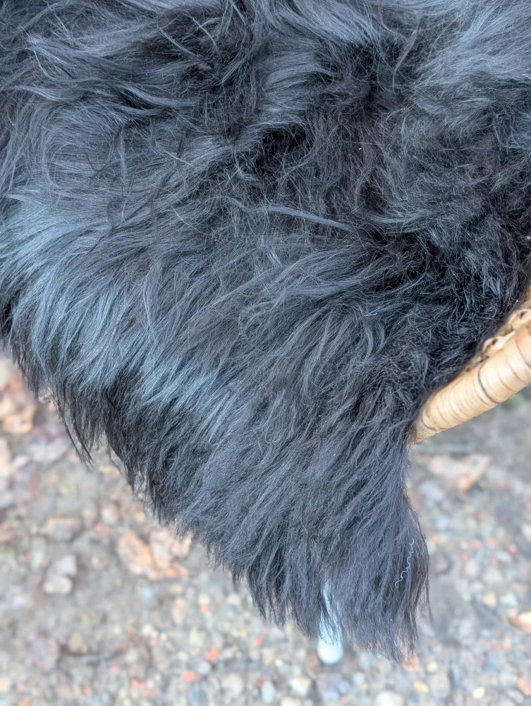 Thick natural black icelandic sheepskin coat with soft long wool and slightly wavy texture perfect for cold weather