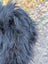A dense shaggy black long wool icelandic sheepskin coat with thick textured natural wool fibers