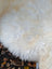 White fluffy british isles sheepskin rug with soft natural texture and cream patches 44 x 30 inches