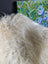 A plush off-white long wool icelandic sheepskin throw with natural curly texture perfect for cozy decor
