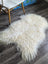 Cream-colored icelandic sheepskins with natural long curly wool and soft fluffy texture perfect for cozy decor