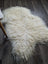 Cream-colored icelandic sheepskin rug with long wool and natural curly fluffy texture for cozy home use