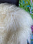 A plush off-white long wool icelandic sheepskin with natural curly fibers perfect for cozy decor