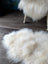 Natural white icelandic sheepskin rug with long wool fibers on dark wood floor perfect for cozy decor