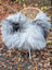 Fluffy natural grey icelandic sheepskin throw with long wool draped over a wicker chair for cozy use