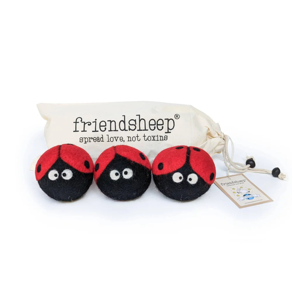 Three red and black felt eco dryer balls with white eyes in a cream drawstring bag ladybug trio set of 3
