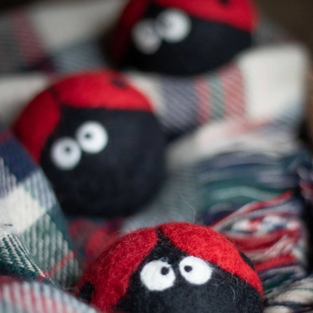 Red and black felt ladybug trio eco dryer balls with white embroidered eyes made from wool for laundry use