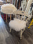 Cream-colored wooden chair with fluffy white merino sheepskin chair pads on seat and backrest for extra comfort