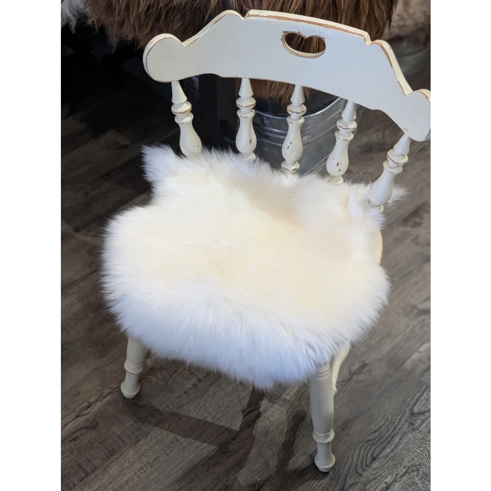 White distressed wooden chair with fluffy white merino sheepskin chair pad for cozy seating comfort