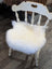 White distressed wooden chair with fluffy white merino sheepskin chair pad for cozy seating comfort