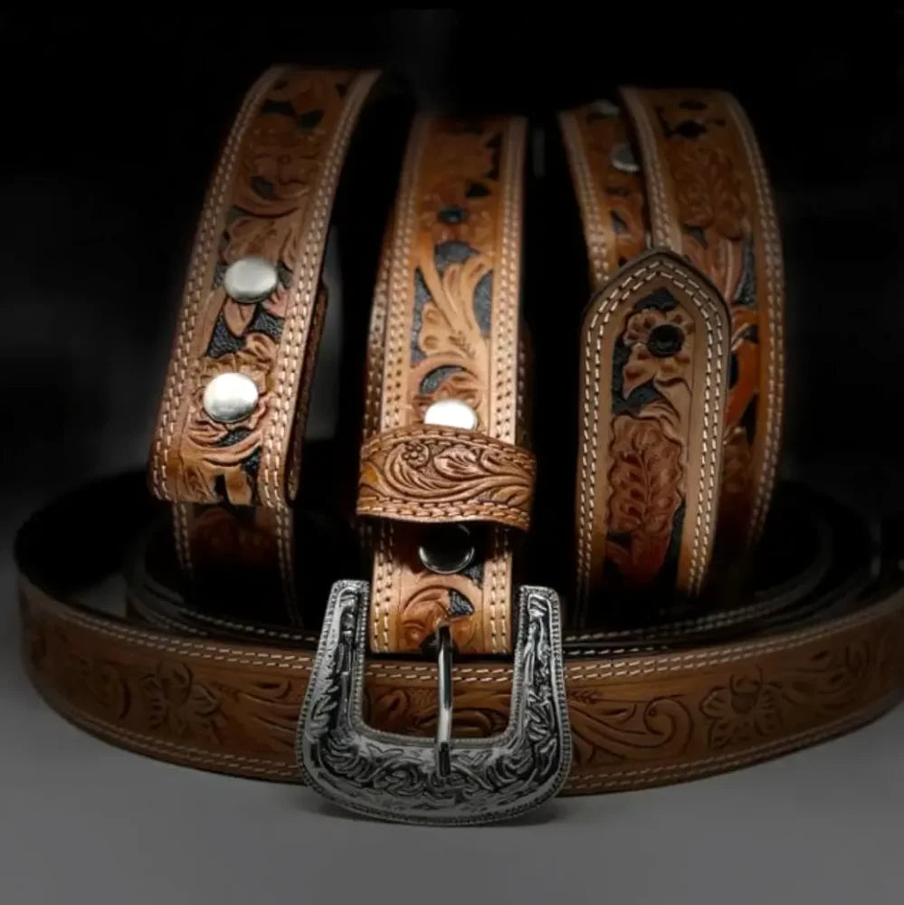 A tan leather belt with intricate floral tooling and silver toned hardware perfect for everyday wear