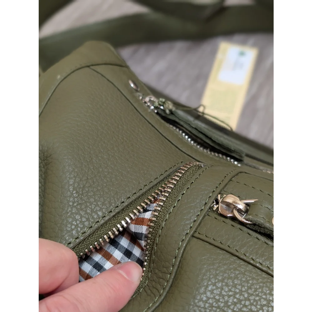 Olive green leather crossbody bag with silver zippers and plaid lining