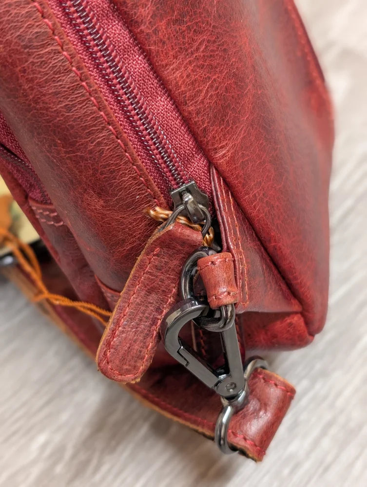 Red wax pull-up leather Ajax sling bag with zipper and carabiner