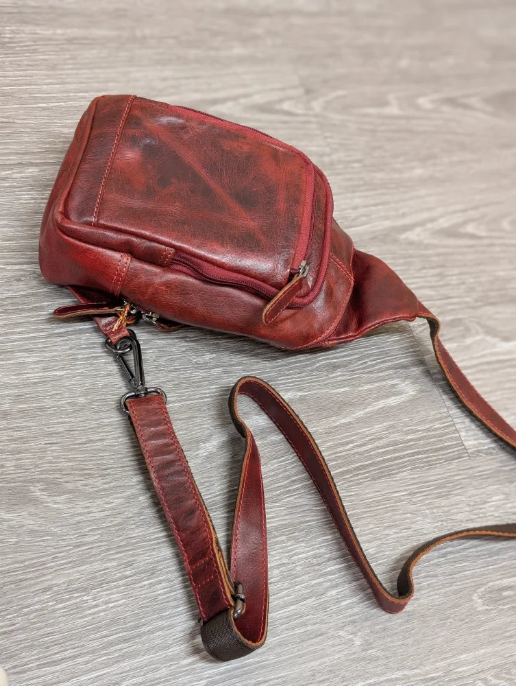 Red Ajax sling bag in distressed wax pull-up leather with adjustable strap