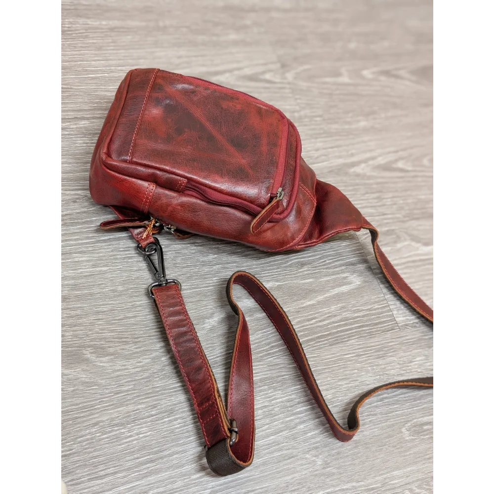 Red Ajax sling bag in distressed wax pull-up leather with adjustable strap