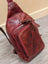 Red wax pull-up leather Ajax sling bag with distressed texture and stitching
