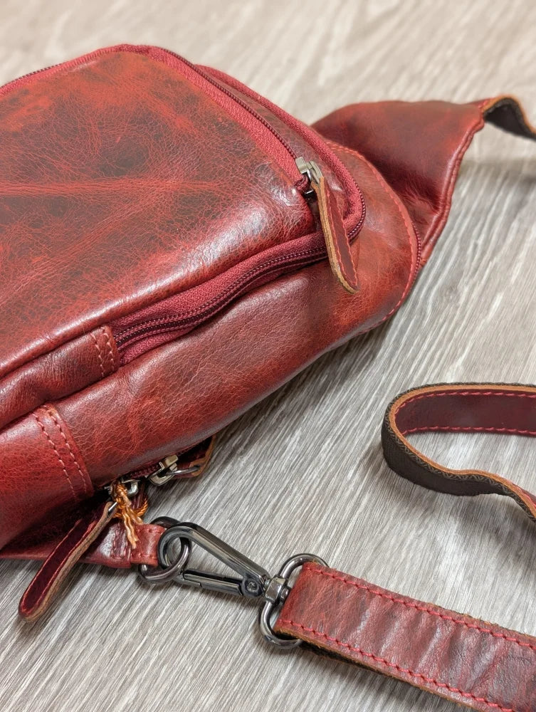 Red wax pull-up leather Ajax sling bag with distressed finish and metal clasp