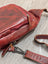 Red wax pull-up leather Ajax sling bag with distressed finish and metal clasp