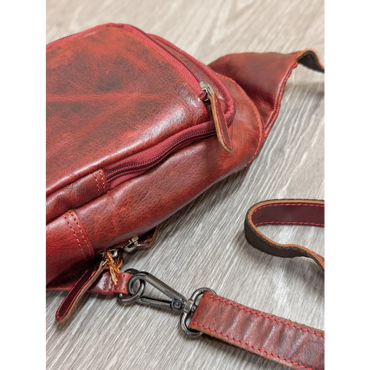 Red wax pull-up leather Ajax sling bag with distressed finish and metal clasp