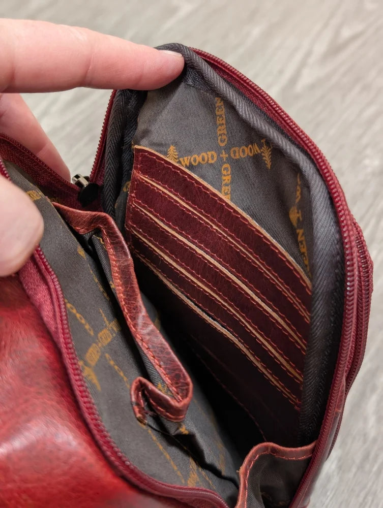 Red wax pull-up leather Ajax sling bag with gray interior and gold branding