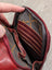 Red wax pull-up leather Ajax sling bag with gray interior and gold branding