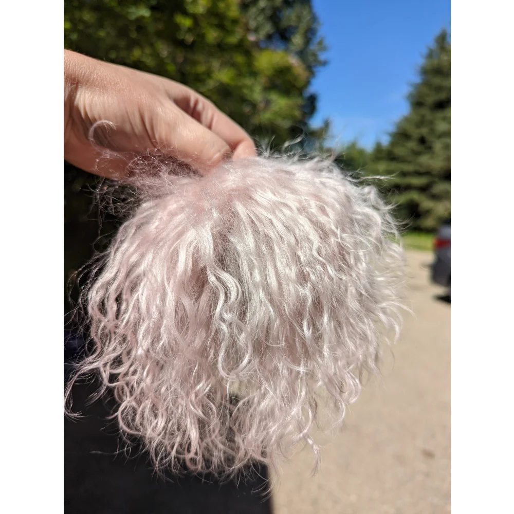 Light pink sheepskin pom pom with curly white fur and pink highlights by Angus Oliver