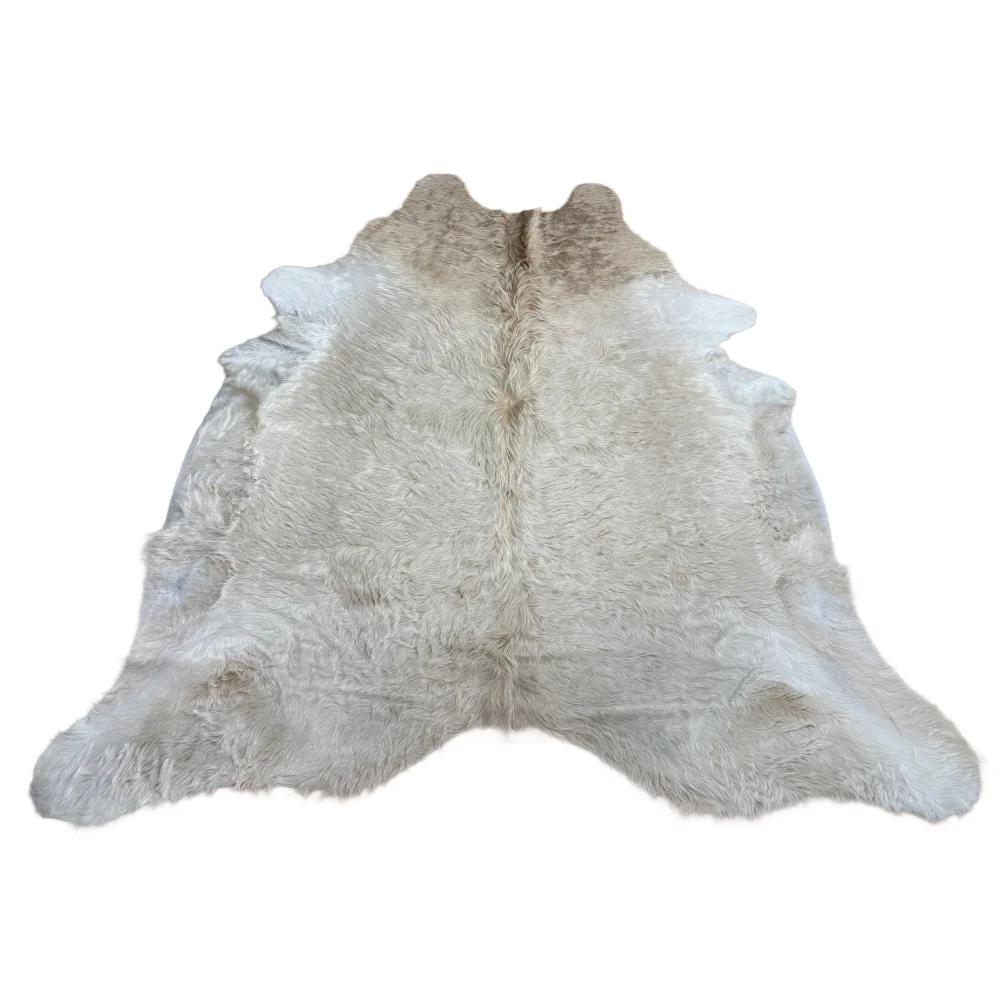 A soft extra large white cowhide rug with rustic charm and unique beige patch and fluffy texture arriving soon