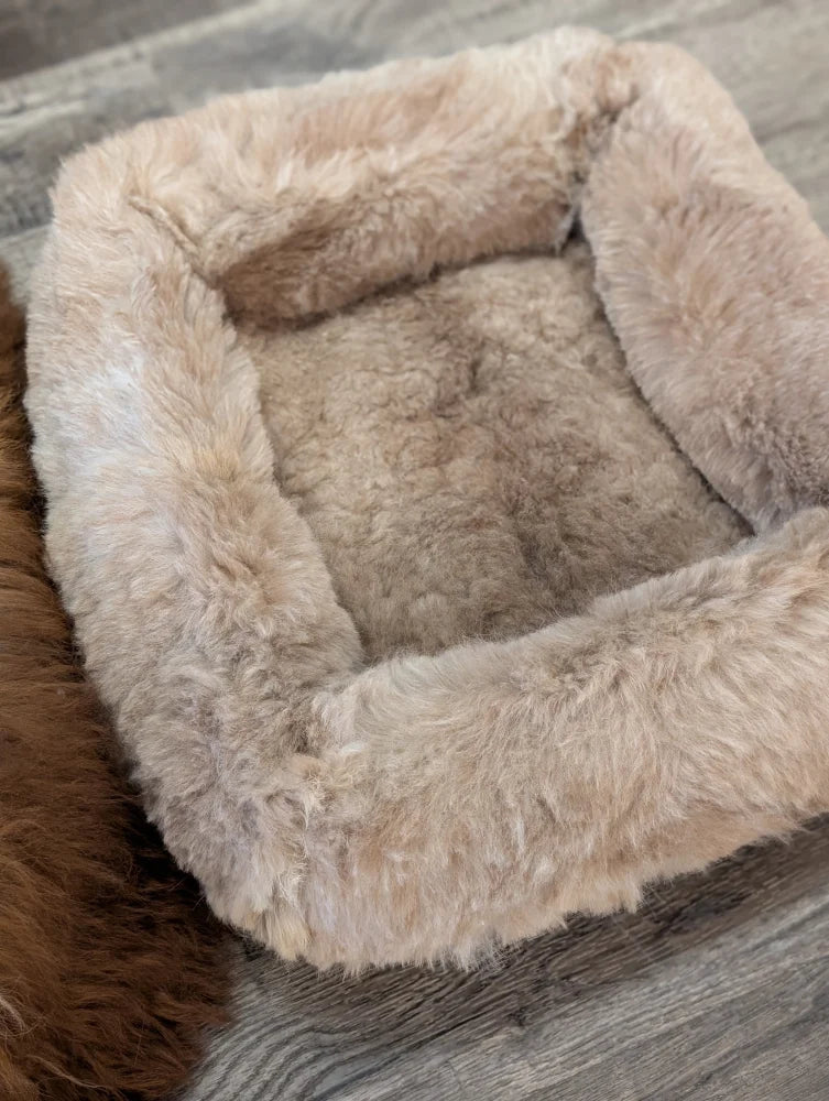 Cozy beige sheepskin pet bed with plush faux fur lining