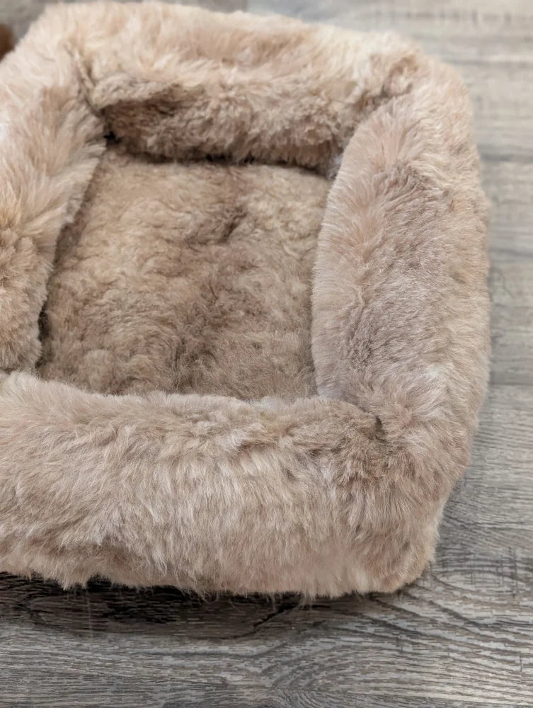 Cozy beige faux fur sheepskin pet bed with plush highland sheepskin design