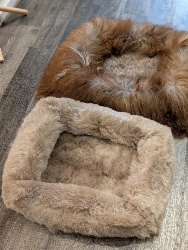 Cozy tan faux fur sheepskin pet bed with plush interior and rounded corners
