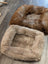 Cozy tan faux fur sheepskin pet bed with plush interior and rounded corners