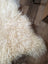 Cream-colored icelandic sheepskins rug with long wool and natural curly texture perfect for cozy decor