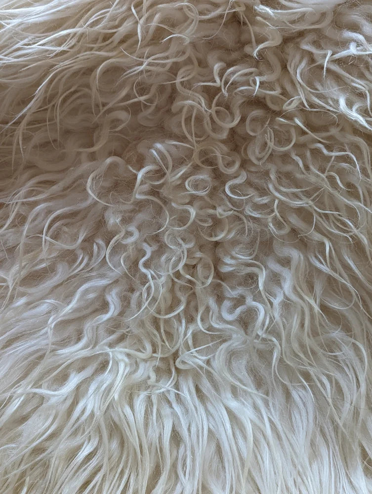 Cream-colored icelandic sheepskins rug with long wool and plush soft texture perfect for cozy decor